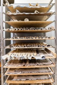 Une étagère en boulangerie qui montre des baguettes de pain avant leur cuisson