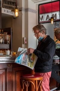 Homme qui lit le journal au bar